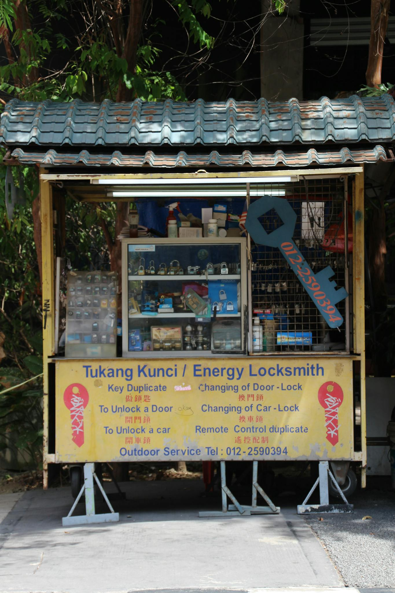 Outdoor locksmith kiosk with key cutting services, displaying tools and locks.